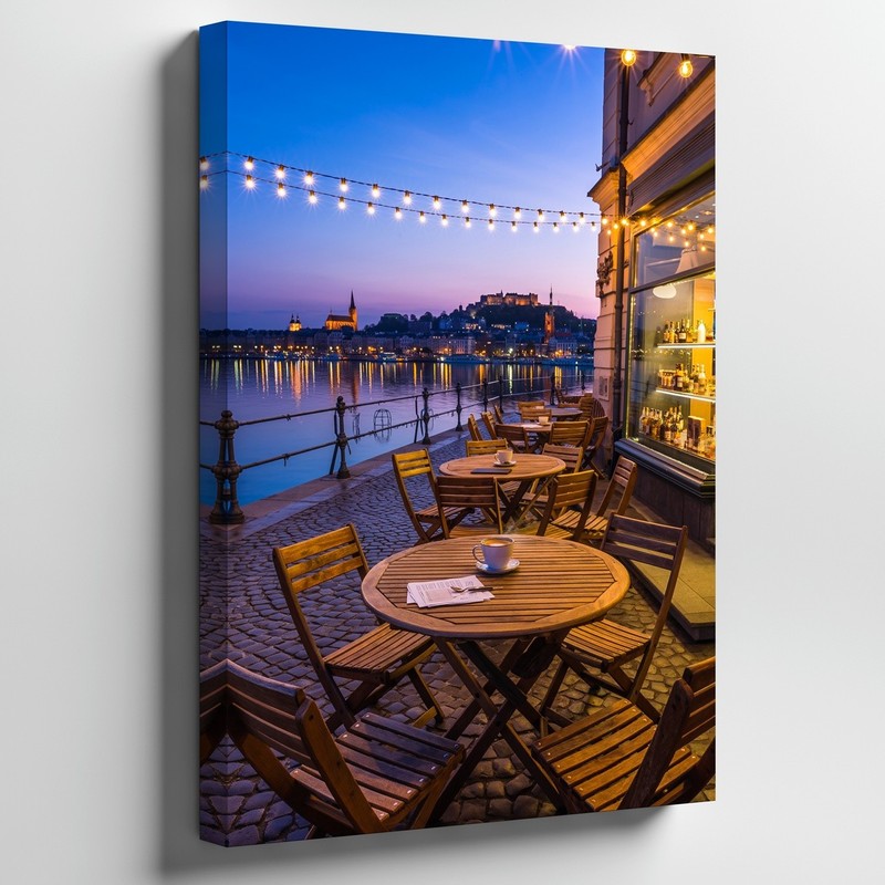 Cozy Outdoor Café Scene At Dusk, Featuring A Round Wooden Wall Art Canvas Print